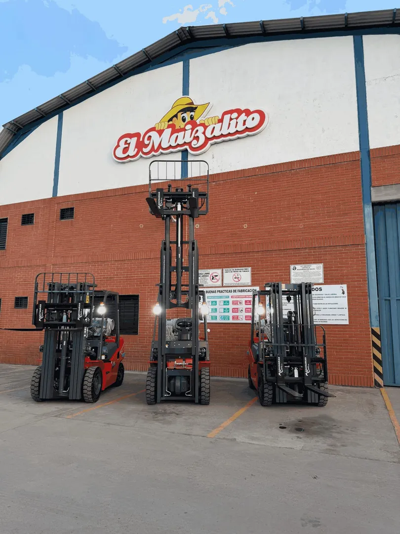 Tres montacargas rojos rotulados Maquinarias Carli, estacionados frente al galpón de una planta.
