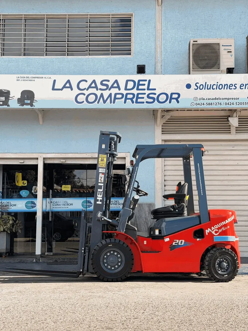 Montacargas Heli de 2 toneladas, nuevo, rotulado con la marca y la web de Maquinarias Carli, estacionado frente al local de un cliente.